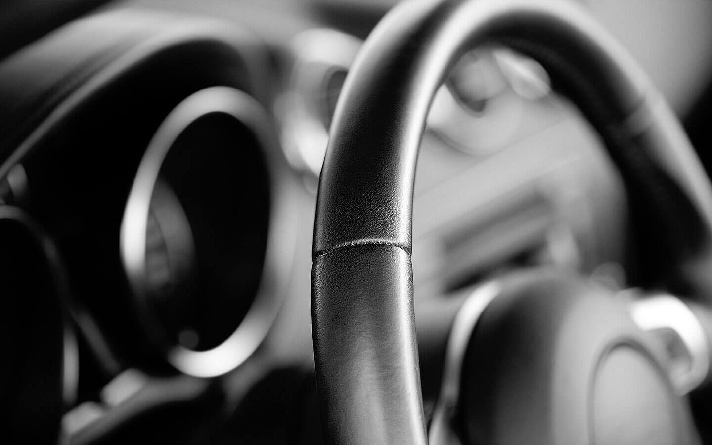 Ein Close-up von einem schwarzen Lenkrad aus Leder, einem Anwendungsbeispiel von thermoplastischem Klebstoff. | Abifor